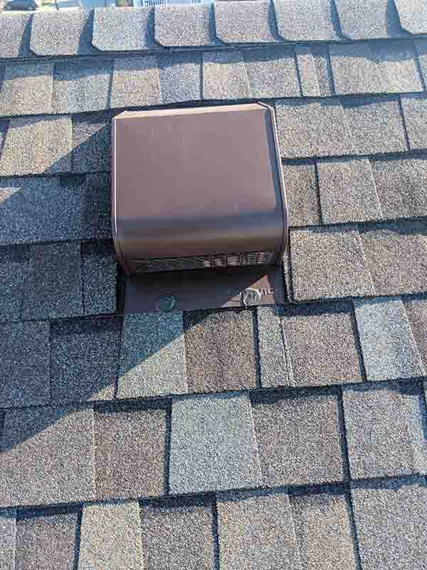 Brown roof vent on asphalt shingles.