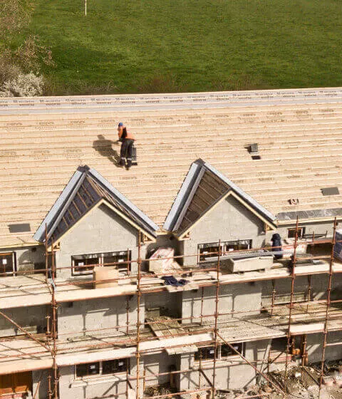Ice damming on roof creating long icicles along house gutter in cold weather